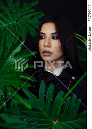 portrait of a beautiful brunette woman of oriental appearance and green plant 71734042