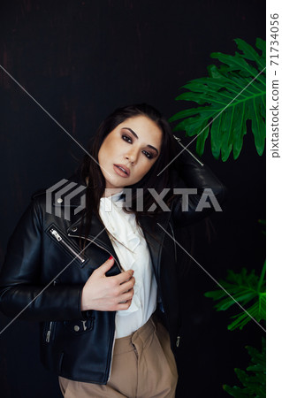 portrait of a beautiful brunette woman of oriental appearance and green plant 71734056