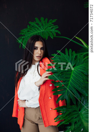 portrait of a beautiful brunette woman of oriental appearance and green plant 71734072
