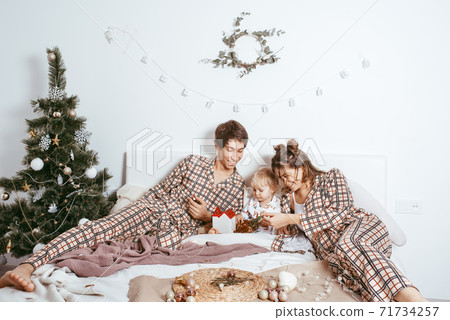 Merry Christmas and happy holidays Parents and young son have fun and play together near the Christmas tree indoors. 71734257