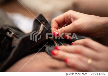 Women's hands taking off men's pants 71734707