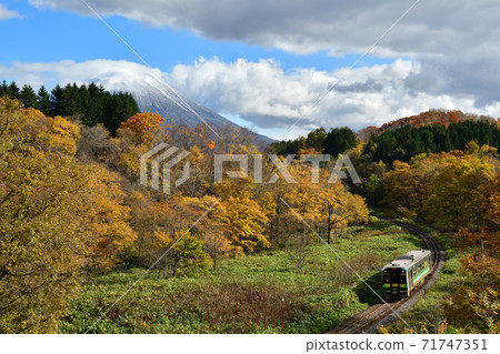 白雪覆蓋的羊蹄山 秋天的樹林和h100常規火車 照片素材 圖片 圖庫