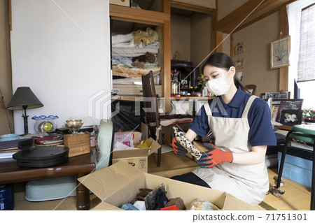 Female worker cleaning up a messy room Female worker cleaning up a messy room 71751301