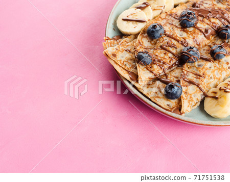 Crepes with chocolate nut spread, banana, berries 71751538