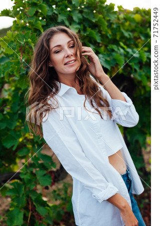 Beautiful fashionable woman in the garden of grape harvest 71752449