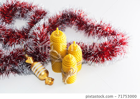 a group of wax candles tied with a rope. Natural wax. On light background. Christmas, new year. 71753000