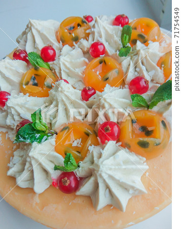 Raw vegan passionfruit cake decorated with berry and cream. Mango filling jelly vegetarian cashew cream cheesecake gluten free. Lactose sugar free desert on white plate. Indoor photo Raw vegan passionfruit cake decorated with berry and cream. Mango filling jelly vegetarian cashew cream cheesecake gluten free. Lactose sugar free desert on white plate. Indoor photo 71754549
