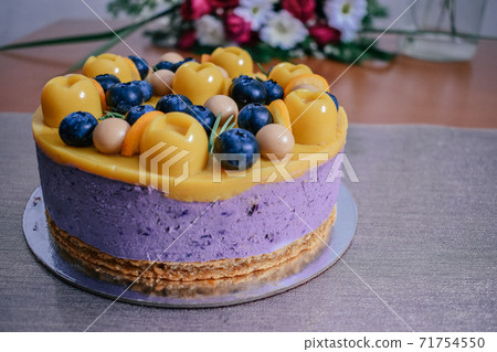 Raw vegan blueberry cake decorated with berry. Mango filling jelly vegetarian cashew cream cheesecake gluten free. Lactose sugar free holiday birthday desert. Indoor photo Raw vegan blueberry cake decorated with berry. Mango filling jelly vegetarian cashew cream cheesecake gluten free. Lactose sugar free holiday birthday desert. Indoor photo 71754550