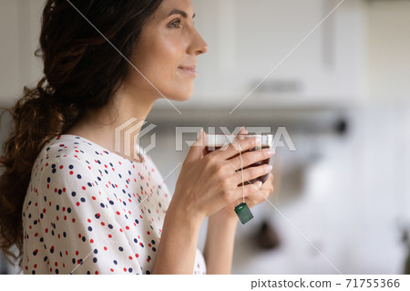 Woman drink warm tea at home dreaming Woman drink warm tea at home dreaming 71755366