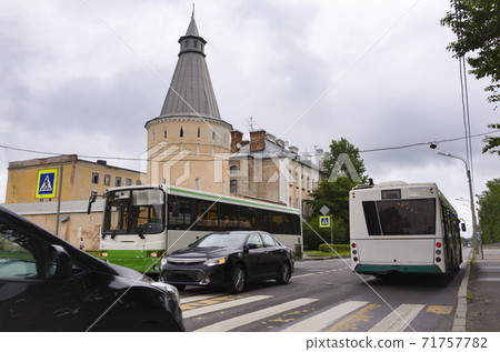Petersburg street in the afternoon in autumn, old fortress wall with a tower, road with cars and bus 71757782
