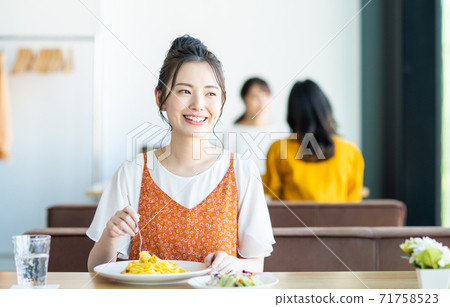 Young woman eating lunch at a restaurant Young woman eating lunch at a restaurant 71758523