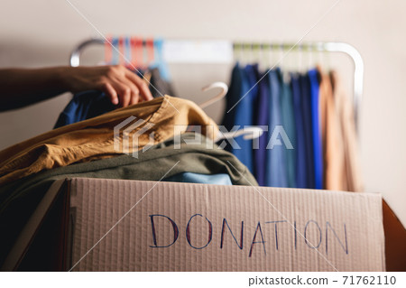 Donation Concept. Preparing Used Old Clothes from Wardrobe Rack into a Donate Box. Focus on Text Donation Concept. Preparing Used Old Clothes from Wardrobe Rack into a Donate Box. Focus on Text 71762110