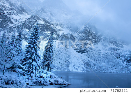 Winter mountain landscape. Icy lake in winter snowy forest. Beautiful frozen nature. Winter mountain landscape. Icy lake in winter snowy forest. Beautiful frozen nature. 71762321