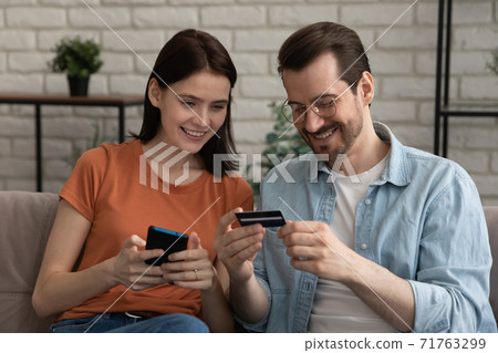 Smiling millennial caucasian couple shopping in mobile application. 71763299