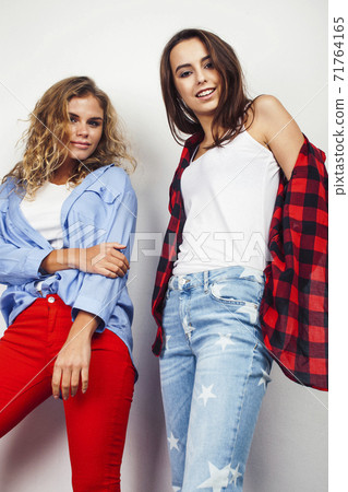 best friends teenage girls together having fun, posing emotional on white background, besties happy smiling, lifestyle people concept, blond and brunette multi nations 71764165