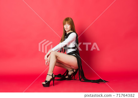 Young beautiful dancer posing in studio on red background Young beautiful dancer posing in studio on red background 71764382