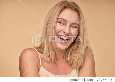Adult lady in shirt looking away and smiling in studio Adult lady in shirt looking away and smiling in studio 71766223