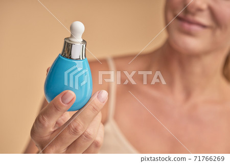 Happy lady holding professional face care product Happy lady holding professional face care product 71766269