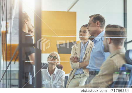 Brainstorming meeting. Group of multi ethnic business people discussing something while working together in modern office Brainstorming meeting. Group of multi ethnic business people discussing something while working together in modern office 71766284