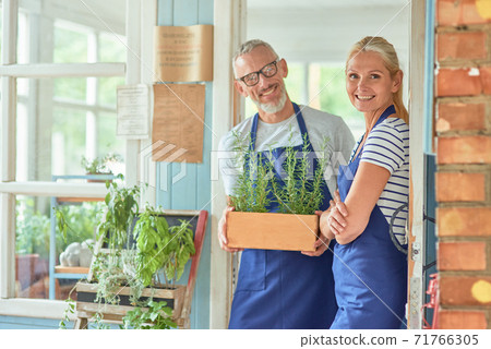 Middle aged couple standing in doorlet of garden house Middle aged couple standing in doorlet of garden house 71766305