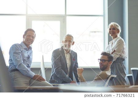 Successful business team working together in the modern office, discussing something and smiling while having a meeting. Teamwork and collaboration concept Successful business team working together in the modern office, discussing something and smiling while having a meeting. Teamwork and collaboration concept 71766321