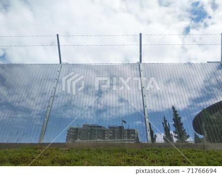 MELAKA, MALAYSIA -JUNE 5, 2020: Anti-climb fencing made from galvanized iron install at the perimeter or property boundary to prevent from the intruder. Its close nets can prevent intruders from climb MELAKA, MALAYSIA -JUNE 5, 2020: Anti-climb fencing made from galvanized iron install at the perimeter or property boundary to prevent from the intruder. Its close nets can prevent intruders from climb 71766694