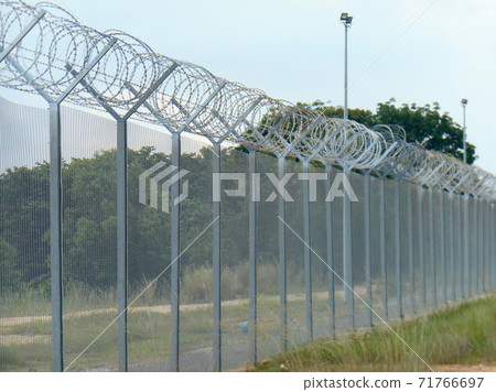 MELAKA, MALAYSIA -JUNE 5, 2020: Anti-climb fencing made from galvanized iron install at the perimeter or property boundary to prevent from the intruder. Its close nets can prevent intruders from climb MELAKA, MALAYSIA -JUNE 5, 2020: Anti-climb fencing made from galvanized iron install at the perimeter or property boundary to prevent from the intruder. Its close nets can prevent intruders from climb 71766697