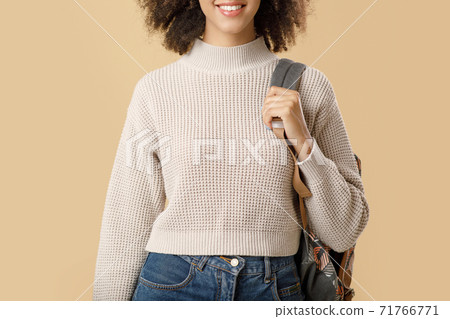 Cheerful millennial african american lady in sweater and glasses with backpack Cheerful millennial african american lady in sweater and glasses with backpack 71766771