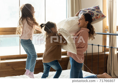 Young mother play battle with two cute daughters 71766807