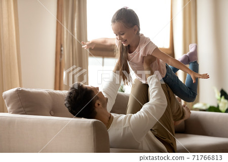 Father lifts up little adorable kid having fun together indoor Father lifts up little adorable kid having fun together indoor 71766813
