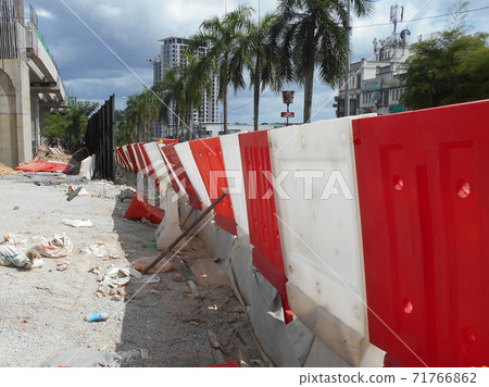 KUALA LUMPUR, MALAYSIA -JUNE 27, 2020: Plastic jersey barrier is a modular barrier that is temporarily used to reroute traffic and protect pedestrians while construction is underway.  71766862