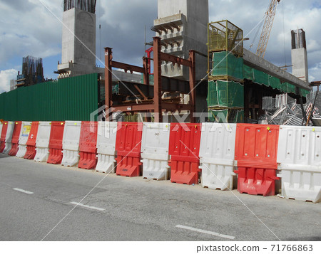 KUALA LUMPUR, MALAYSIA -JUNE 27, 2020: Plastic jersey barrier is a modular barrier that is temporarily used to reroute traffic and protect pedestrians while construction is underway. KUALA LUMPUR, MALAYSIA -JUNE 27, 2020: Plastic jersey barrier is a modular barrier that is temporarily used to reroute traffic and protect pedestrians while construction is underway. 71766863