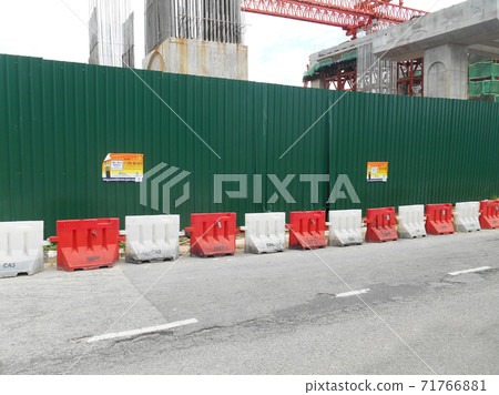 KUALA LUMPUR, MALAYSIA -JUNE 27, 2020: Plastic jersey barrier is a modular barrier that is temporarily used to reroute traffic and protect pedestrians while construction is underway. KUALA LUMPUR, MALAYSIA -JUNE 27, 2020: Plastic jersey barrier is a modular barrier that is temporarily used to reroute traffic and protect pedestrians while construction is underway. 71766881