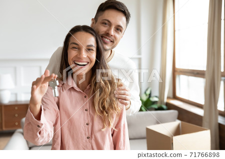 Happy husband hug wife holding keys to the new house Happy husband hug wife holding keys to the new house 71766898