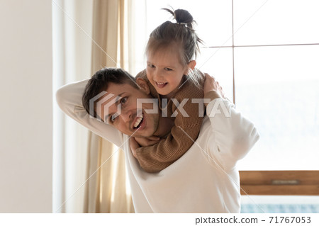 Cute girl piggyback daddy play together at home Cute girl piggyback daddy play together at home 71767053