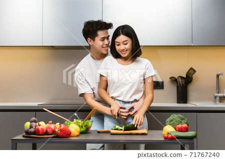 Loving Chinese Husband Hugging Wife Cooking Dinner In Modern Kitchen Loving Chinese Husband Hugging Wife Cooking Dinner In Modern Kitchen 71767240