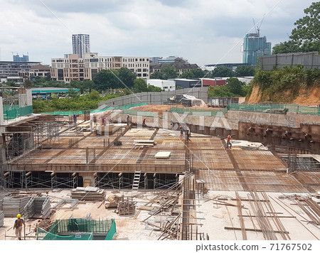 KUALA LUMPUR, MALAYSIA -NOVEMBER 21, 2020: Building floor slab under construction. Construction workers fabricating the timber formwork and installing the steel reinforcement bar. KUALA LUMPUR, MALAYSIA -NOVEMBER 21, 2020: Building floor slab under construction. Construction workers fabricating the timber formwork and installing the steel reinforcement bar. 71767502