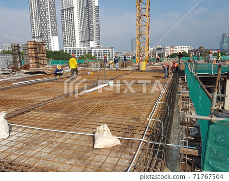 KUALA LUMPUR, MALAYSIA -NOVEMBER 21, 2020: Building floor slab under construction. Construction workers fabricating the timber formwork and installing the steel reinforcement bar.  71767504