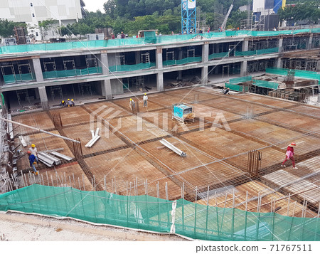 KUALA LUMPUR, MALAYSIA -NOVEMBER 21, 2020: Building floor slab under construction. Construction workers fabricating the timber formwork and installing the steel reinforcement bar. KUALA LUMPUR, MALAYSIA -NOVEMBER 21, 2020: Building floor slab under construction. Construction workers fabricating the timber formwork and installing the steel reinforcement bar. 71767511