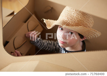 A little boy is playing with cardboard tractor on a white background. Agriculture concept. Mockup for design with copy space. 71768400
