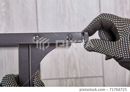 Installing of legs of flat pack furniture by assembler at home. 71768725