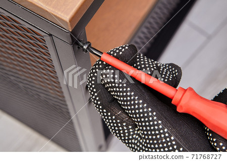 Assembler is mounting flat pack shelf while screwing bolts by screwdriver. 71768727