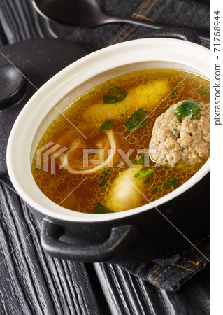 Rindsuppe Brown Beef Soup Recipe close-up in a saucepan. Vertical 71768944