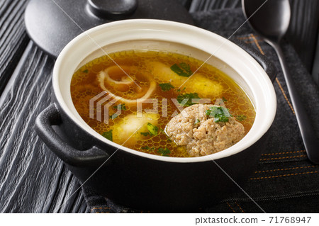 Delicious Viennese rindsuppe soup based on beef broth with dumplings close-up in a saucepan. horizontal Delicious Viennese rindsuppe soup based on beef broth with dumplings close-up in a saucepan. horizontal 71768947