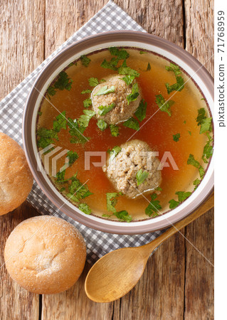 Leberknodelsuppe German liver dumpling soup close-up in a plate. Vertical top view 71768959