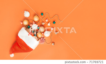 christmas decorations fall out of santa hat on orange background christmas decorations fall out of santa hat on orange background 71769721