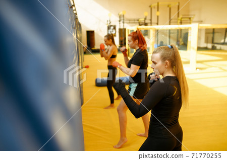 MMA fighters hits the bags in gym, female group 71770255
