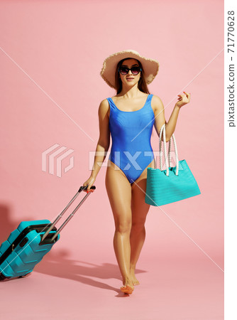 Pretty traveler in swimsuit poses with suitbag Pretty traveler in swimsuit poses with suitbag 71770628