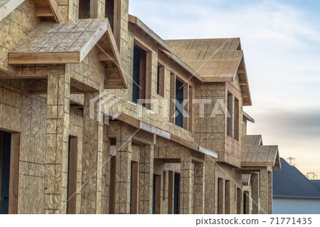 Close up of the exterior of townhomes under construction against cloudy sky Close up of the exterior of townhomes under construction against cloudy sky 71771435