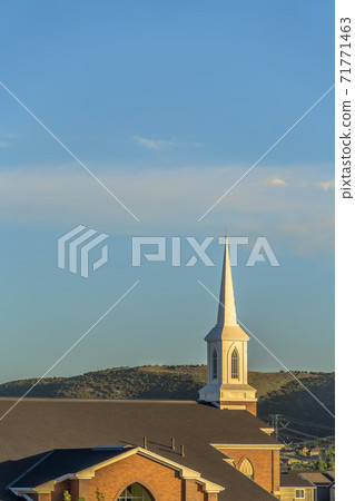 Exterior view of a brick church with focus on roof and steeple on a sunny day 71771463